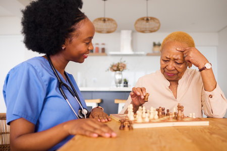 Caregiver sharing a traditional meal with elderly client at home – A home care aide sitting with a senior client, serving a culturally specific meal that respects the client’s traditions.
