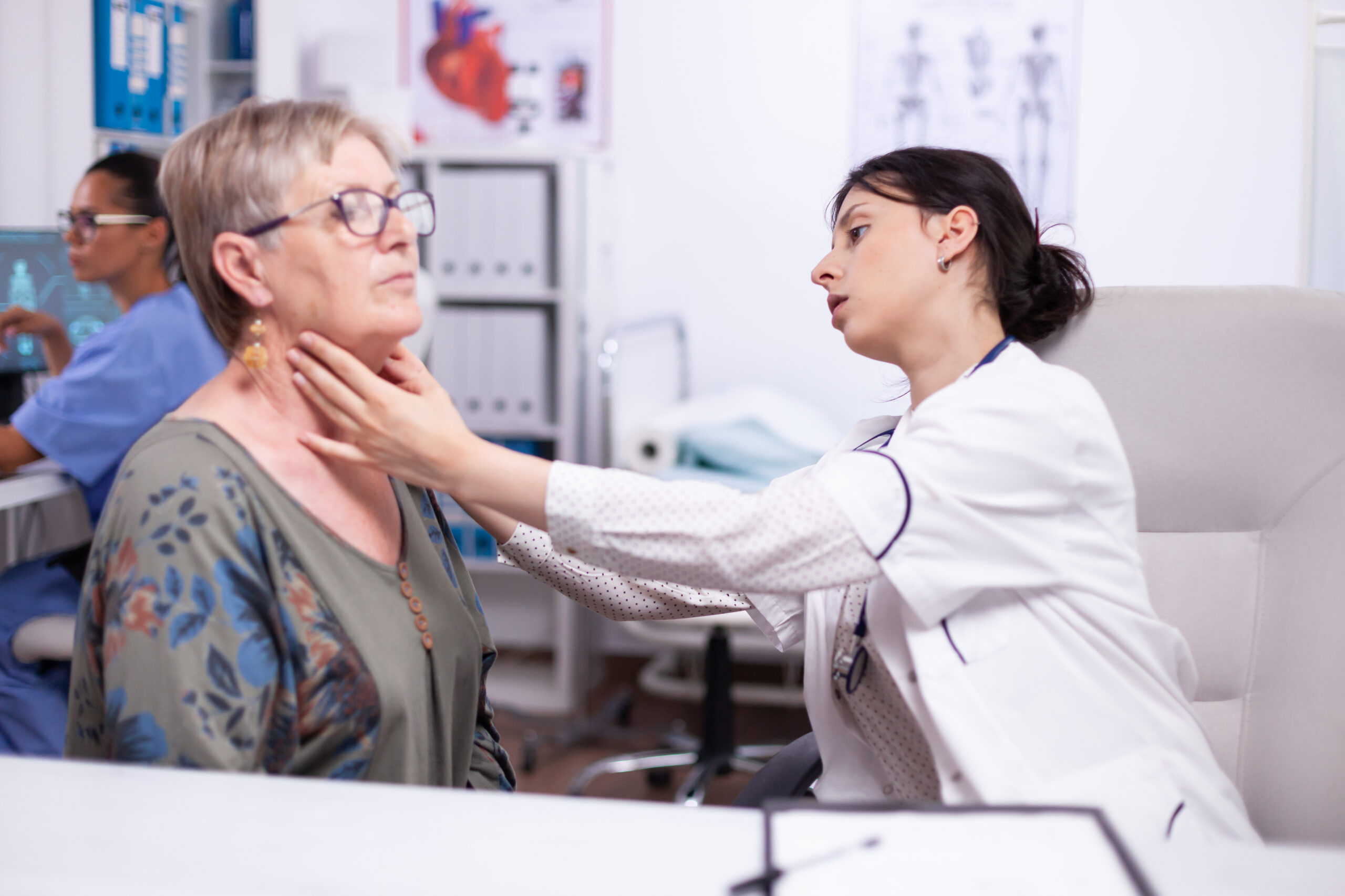 Caregiver assisting senior with in-home health monitoring for thyroid condition